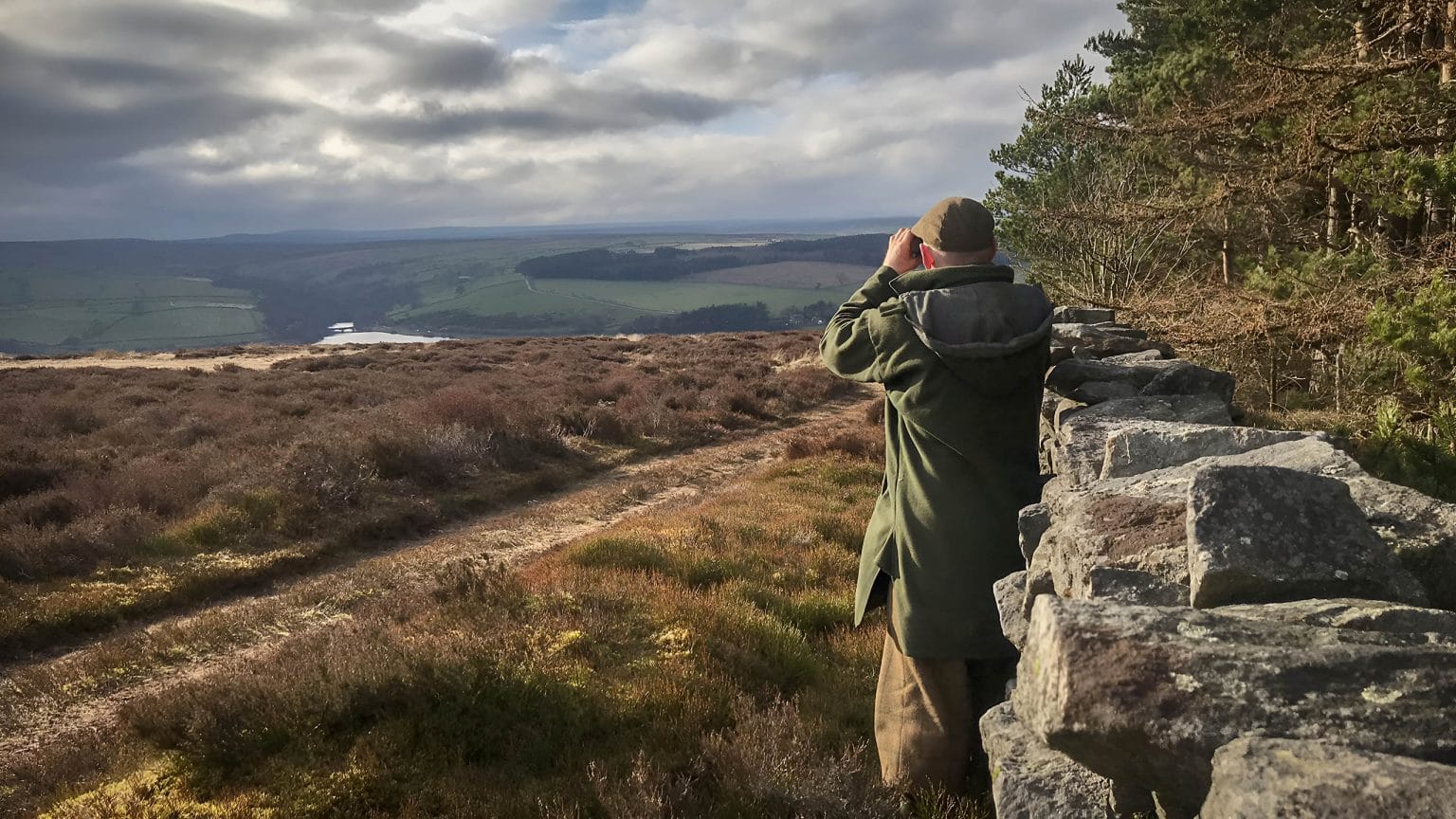 Bird watcher observing wildlife from a moorland viewpoint at Swinton Estate