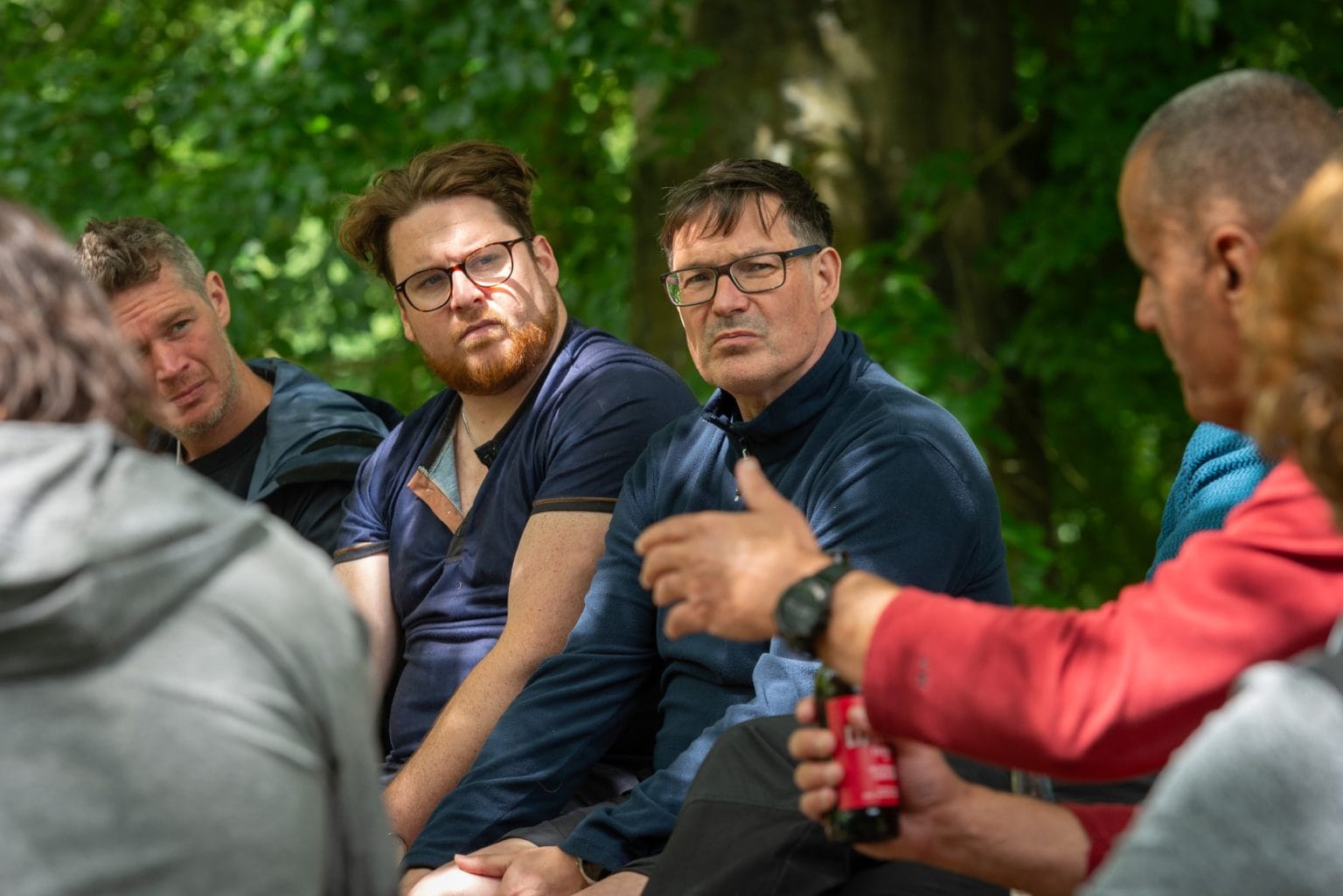 Men participating in a discussion at the Climate Action Academy's Environment Forum, set in the verdant surroundings of Swinton Estate's Deer House